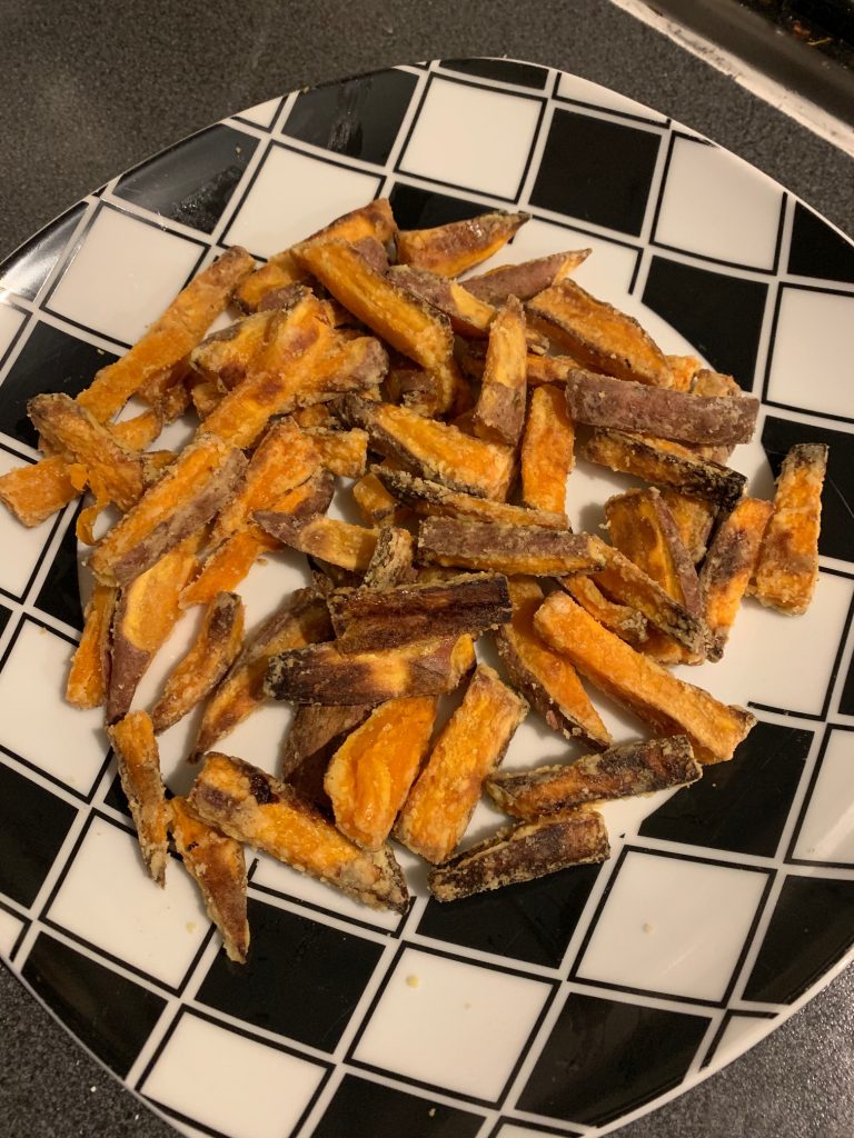 crispy sweet potato fries on a black and white plate