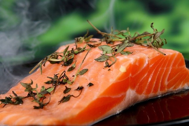 what to serve with salmon - a slice of salmon on a plate covered in herbs